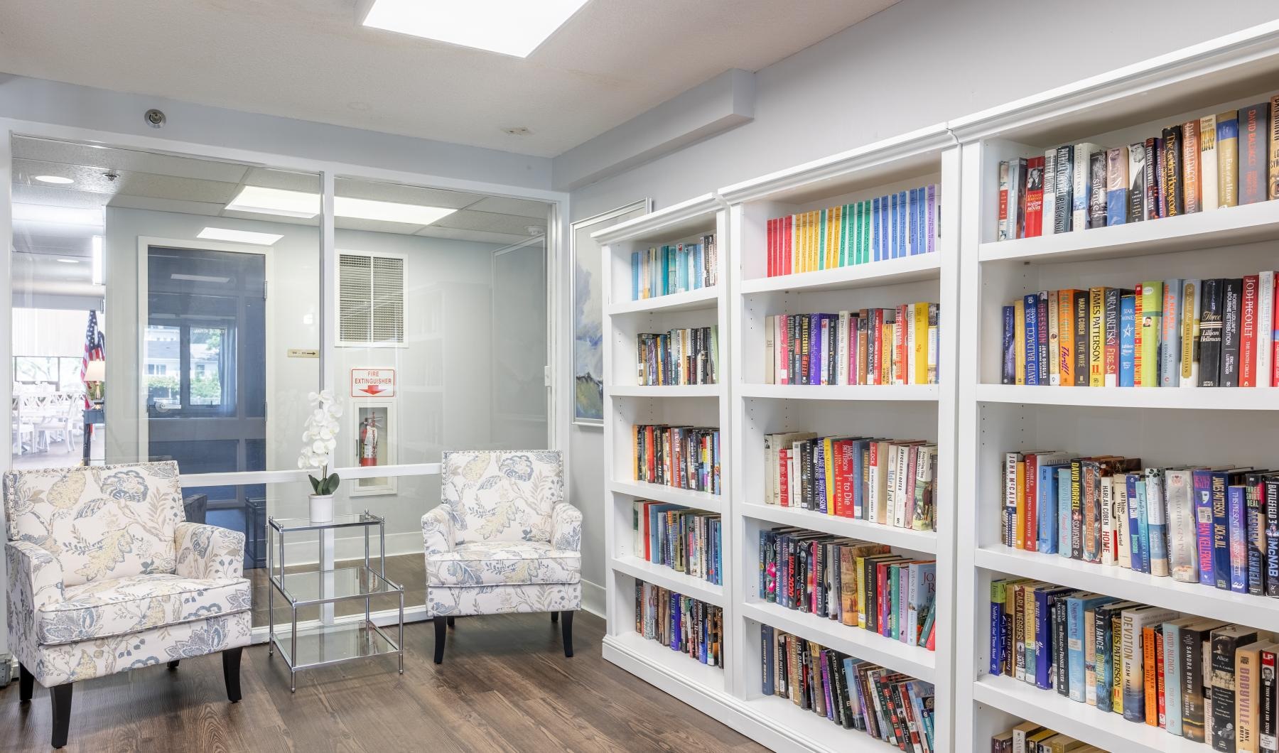 Take advantage of all Serenity Towers at Brockton has to offer a room with a table and chairs and large bookshelves full of books