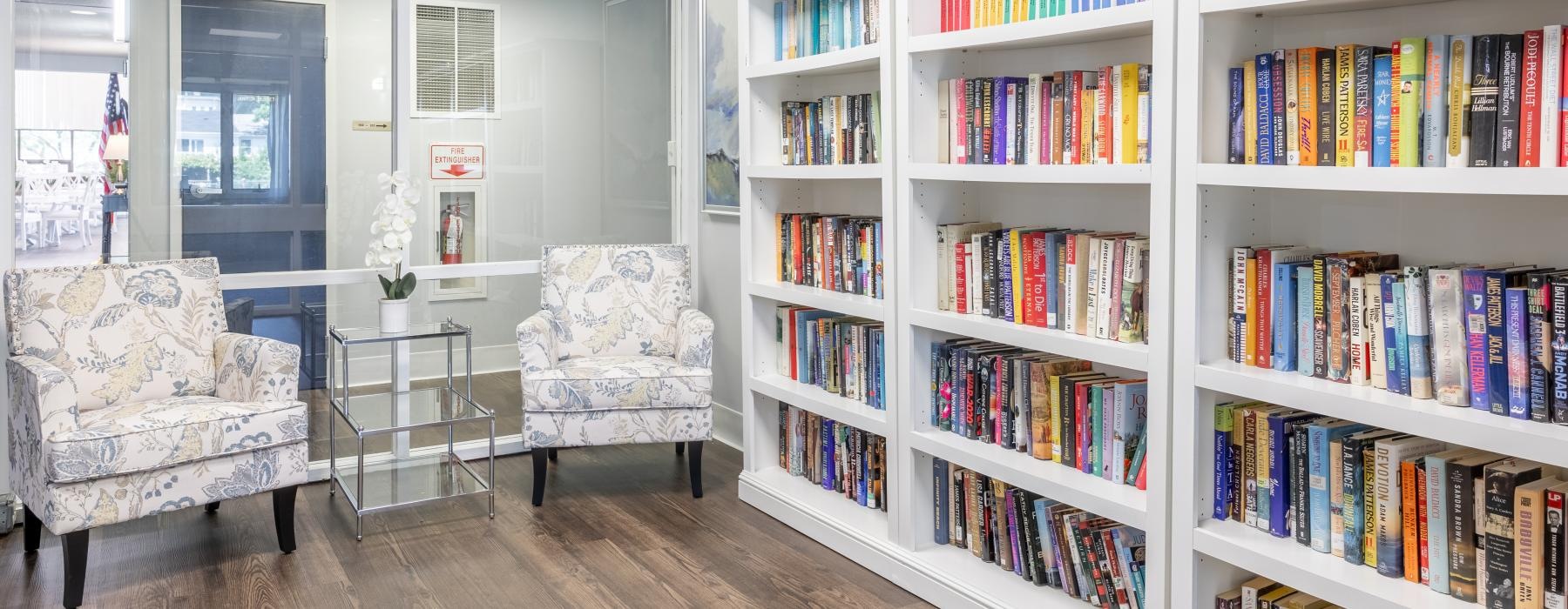 a room with a table and chairs and large bookshelves full of books