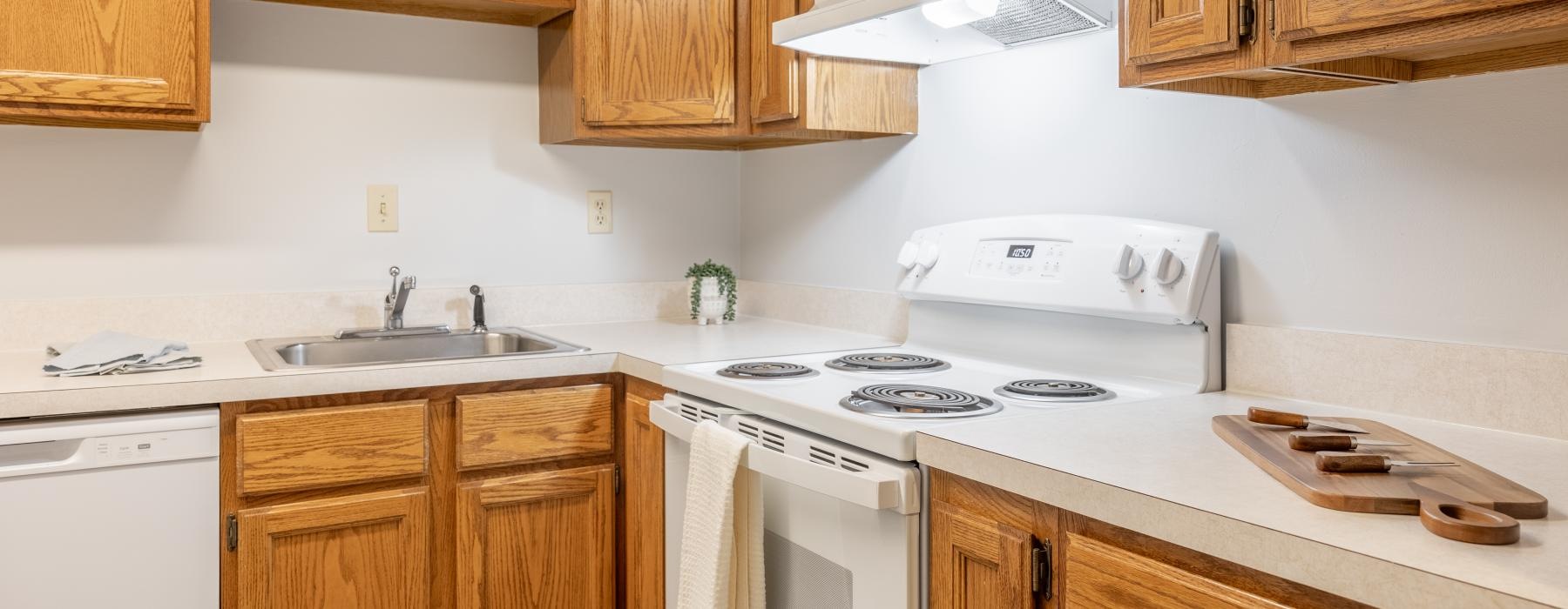 a kitchen with wooden cabinets and white countertops