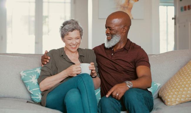 smiling, older couple, sit together on a couch